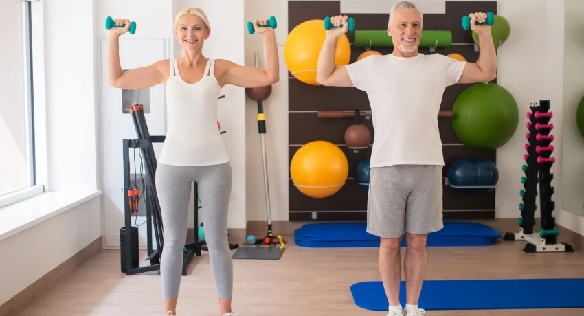 positive-man-woman-exercising-with-dumbbells-raising-their-arms